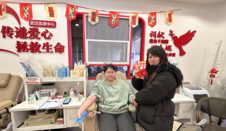 鄧詩彤正在獻血，媽媽陪伴一旁為她點贊。廖淑巧攝