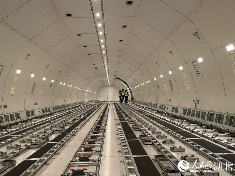 李康和同事正在机舱里等待上货。人民网记者 郭婷婷摄