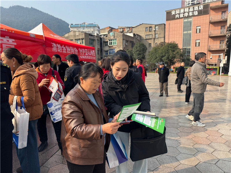 工作人員（右）向群眾講解發放法治宣傳資料