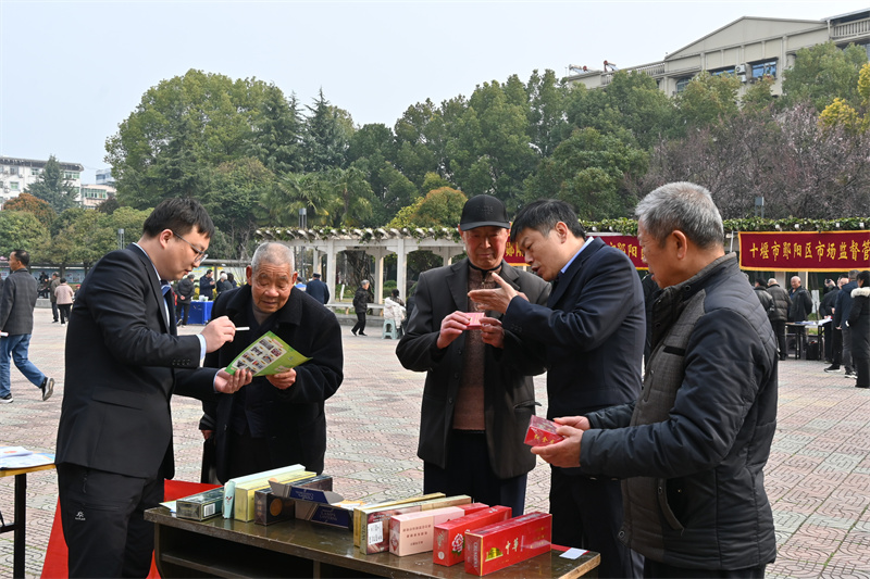 专卖人员向过路群众普及真假烟鉴别知识。王钰婷摄