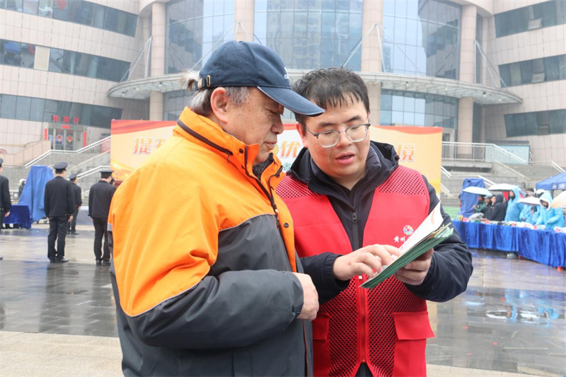 工作人员向围观群众介绍假烟真伪鉴别技巧