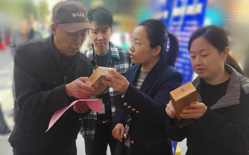 图为咸安区烟草专卖局志愿者为村民讲解假烟辨别技巧