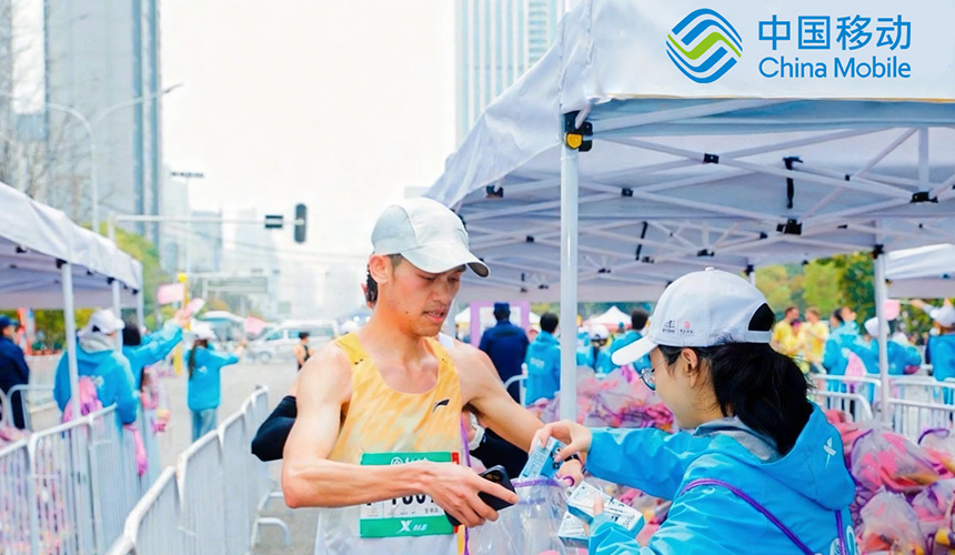 武漢馬拉鬆賽道旁，全球通逐馬志願者熱情服務跑者