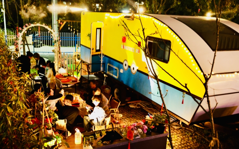 夜幕降臨，露營區燈光營造出浪費的戶外氛圍，游客們盡享休閑樂趣。