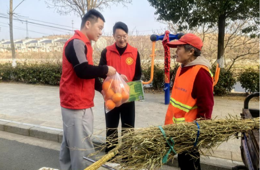 志愿者为环卫工人送上慰问食品。