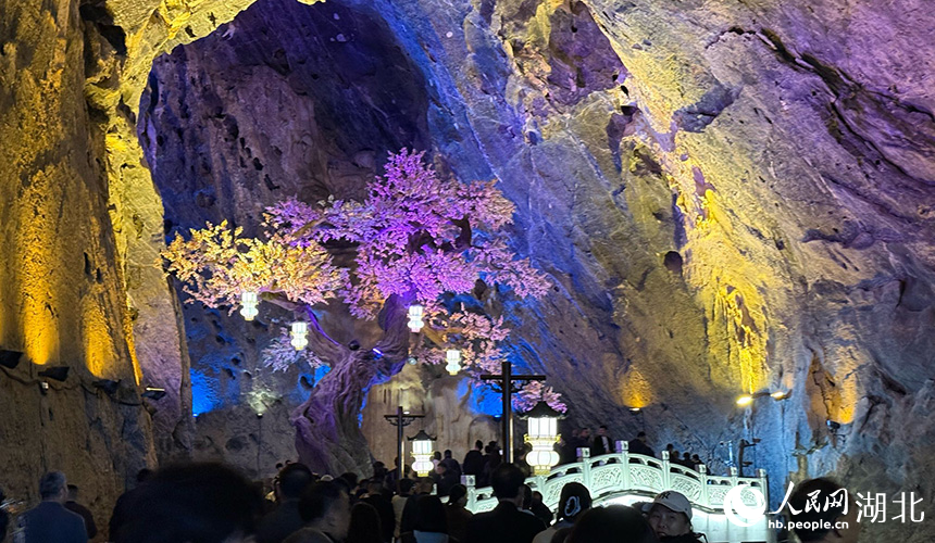 游客在黄仙洞内参观，感受光影与地质奇观的交融。人民网记者 周恬摄
