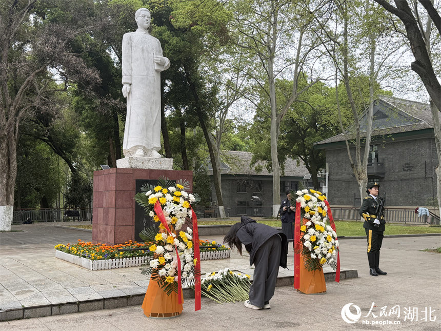 师生向革命烈士恽代英同志敬献鲜花、俯身鞠躬。