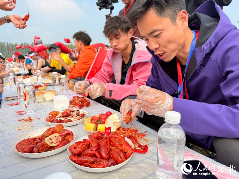 龙虾宴现场，跑着们正大快朵颐。人民网记者 张隽摄