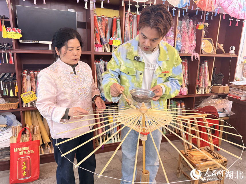 游客体验油纸伞制作。人民网记者 张隽摄