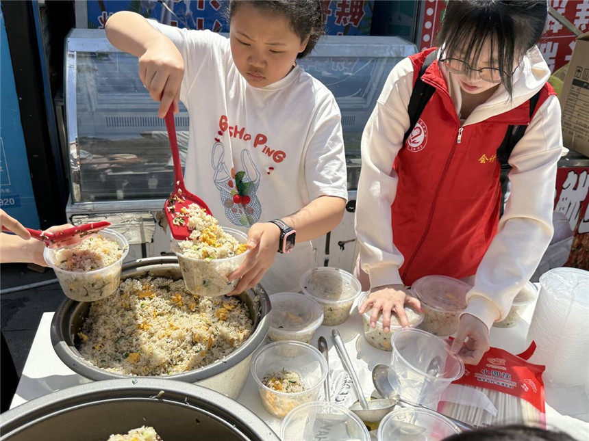 孩子们认真分装每一份炒饭。