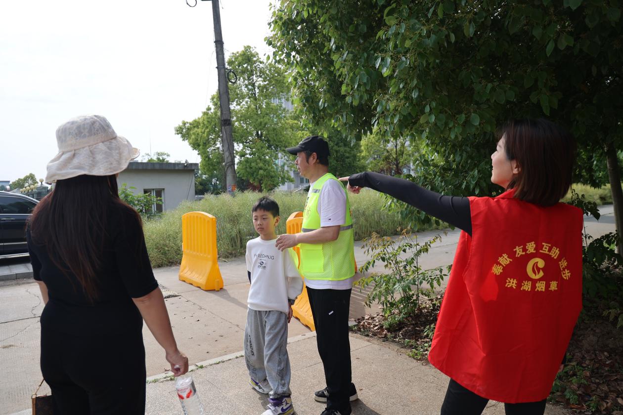 洪湖烟草青年志愿者与驻村干部服务游客。