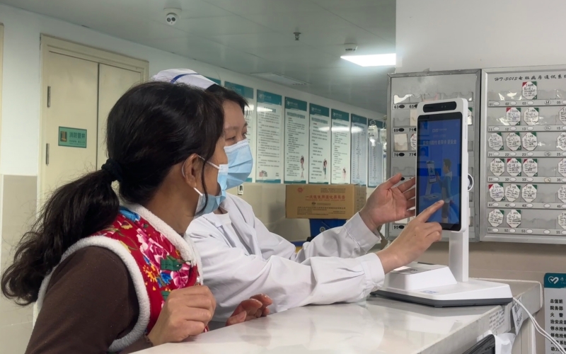 護士為患者家屬介紹“床旁結算”服務。周姿攝