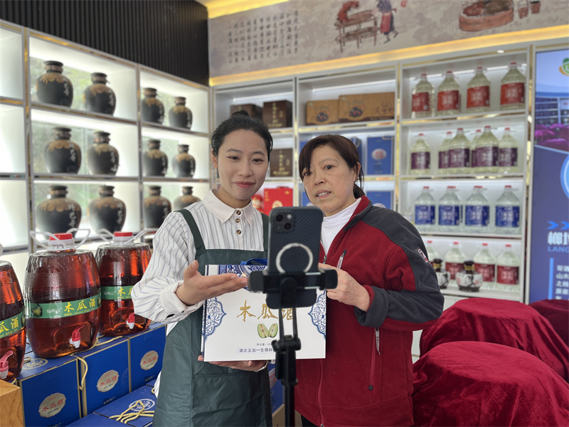 客户经理在店内为游客介绍土家特产。