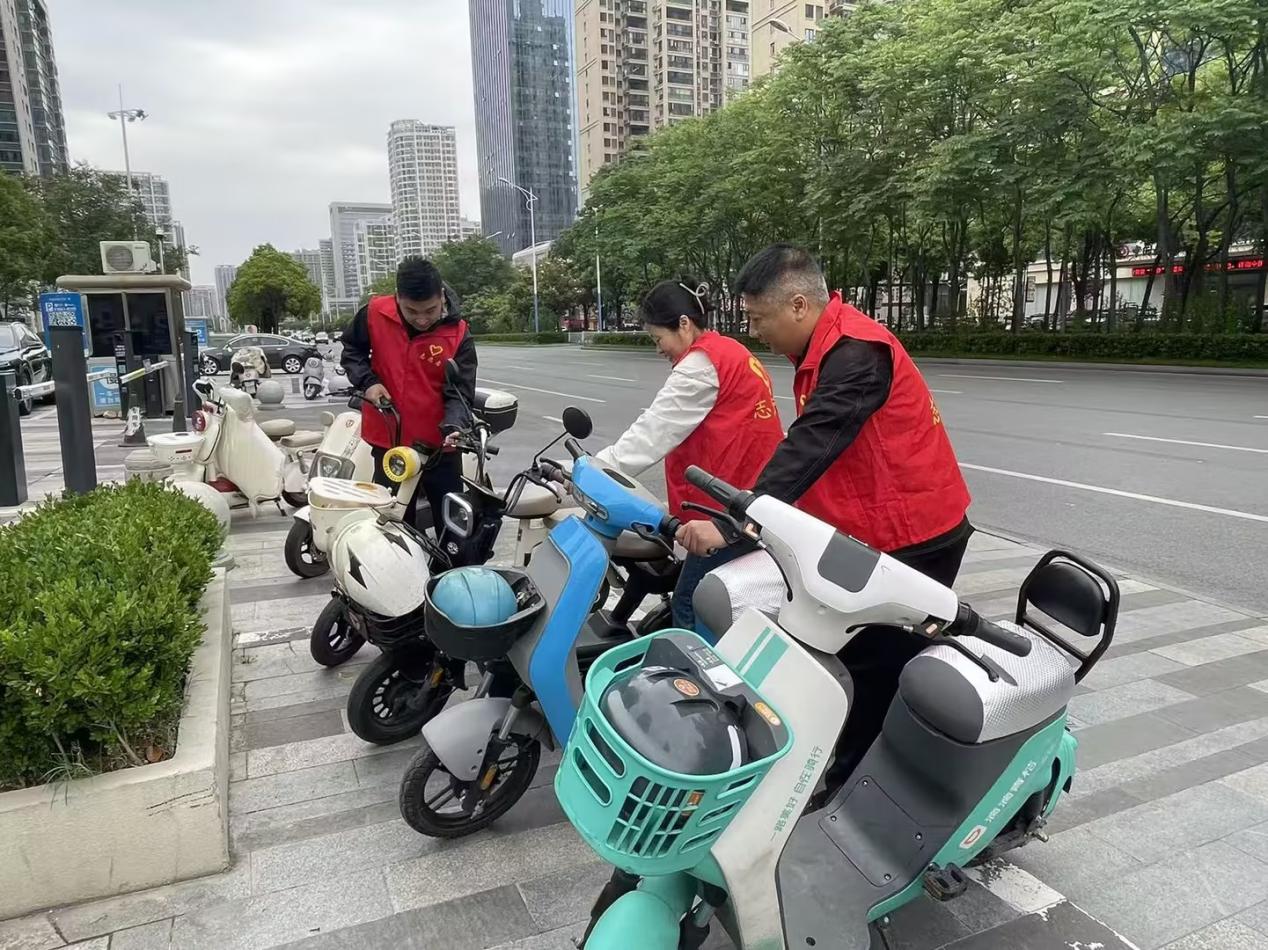 志愿者将电动车摆放整齐。