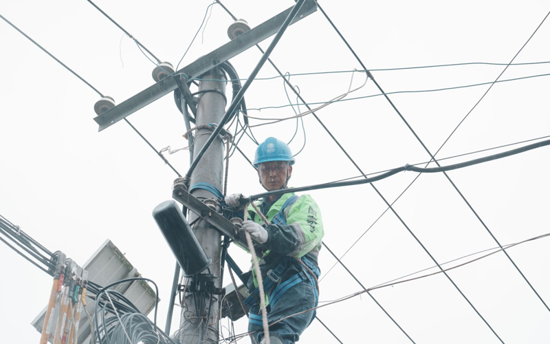 工作人員在雨中開展電纜更換作業。
