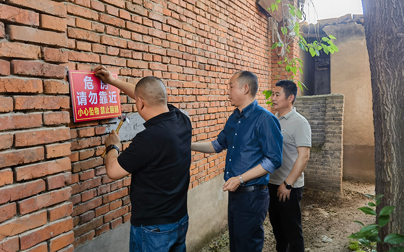 工作人員在資產點安裝警示標語。