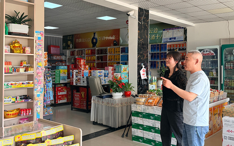 客戶經理指導零售客戶分區陳列商品。