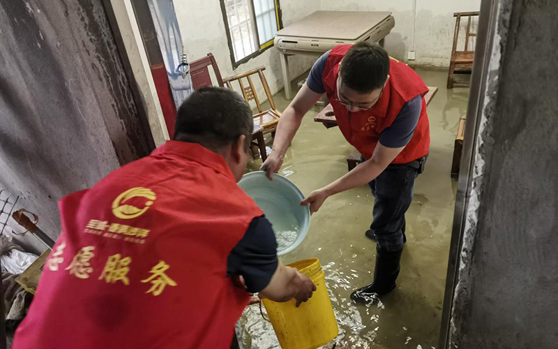 志願服務隊幫助客戶清理店內積水。張向宇攝