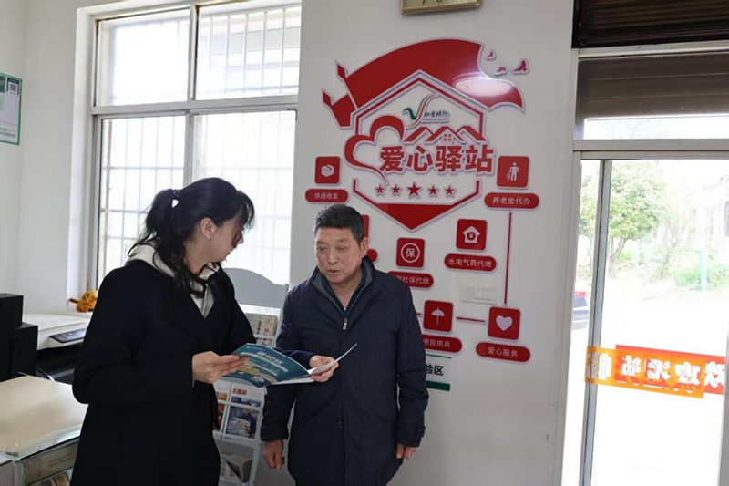 随州烟草工作人员为零售户王晓国讲解爱心驿站优秀案例