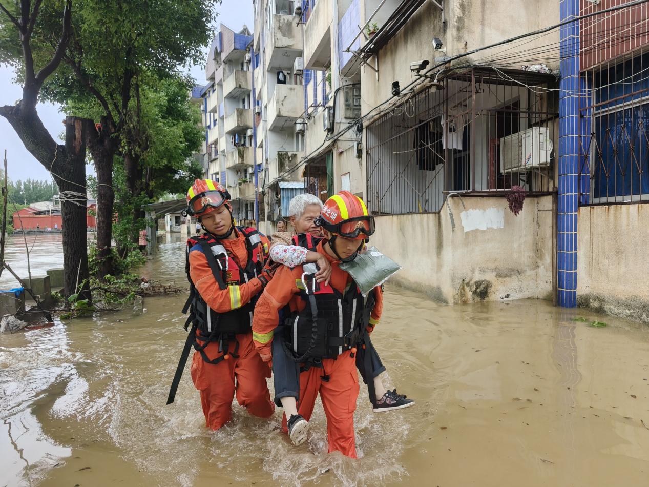 广水市马坪镇军山液化气站附近，消防员转移因暴雨内涝被困的群众。马龙摄