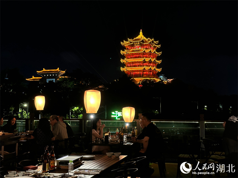 游客登上天台,赏美景、品美食,沉浸式饱览黄鹤楼的璀璨夜景。人民网 彭昀迪摄