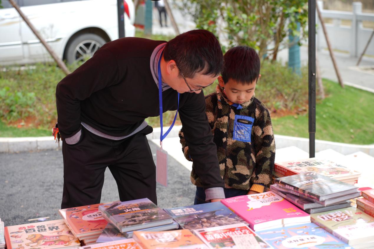 志愿者为现场小孩翻找图书。