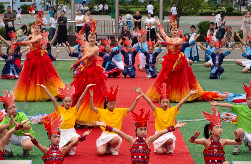 武汉工商学院学生与头戴凤凰头饰的救师口小学学生共舞《凤舞九天》。朱宇光摄