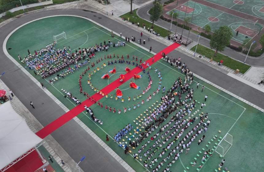 武汉工商学院学生与头戴凤凰头饰的救师口小学学生共舞《凤舞九天》。何轩摄