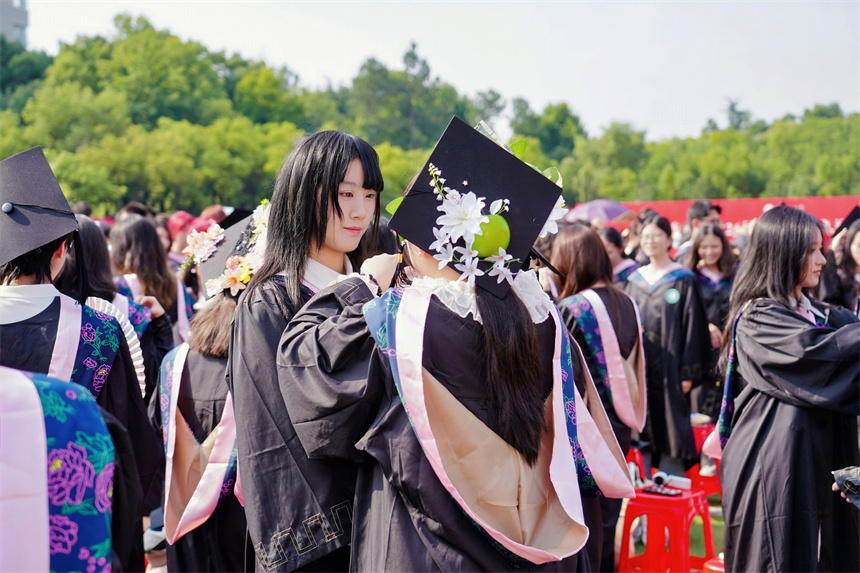 毕业生互相正衣冠。学校供图