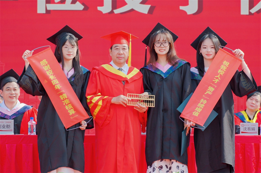 学生送“算盘”与校长合影。