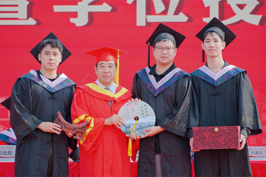 学生送平安扣与校长合影。
