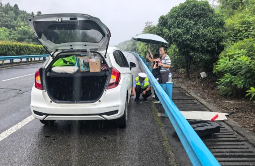 高警二支隊崇陽大隊民警雨中為爆胎車輛更換備胎。