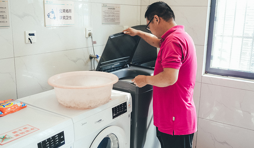 潜江服务区司机之家，张师傅正在使用洗衣机。杨鑫摄