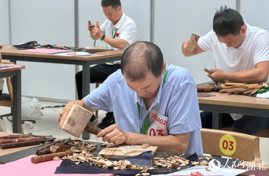 木雕项目，选手挥锤凿木。人民网记者 张沛摄