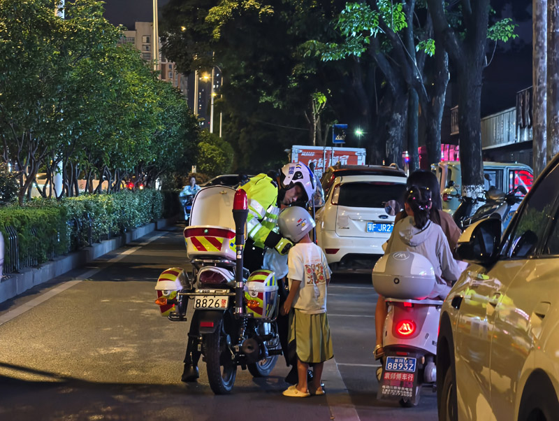 曾怀庆巡逻途中发现一名母亲骑电动自行车搭载两名儿童，立即上前提醒其规范佩戴安全头盔，并将超员儿童转运至自己的警用摩托车上。
