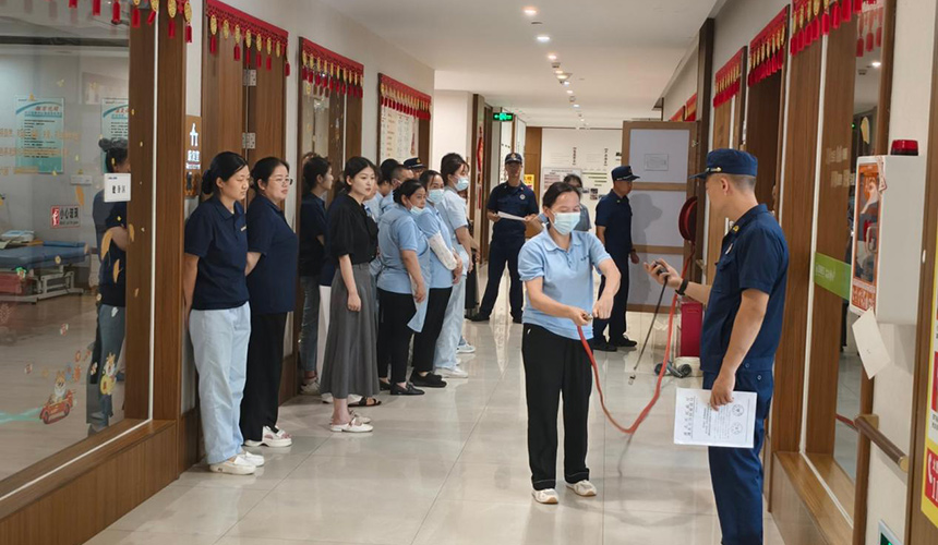 武汉市消防救援局消防员向养老服务机构医护、护理及消防控制室值班人员和后勤工作人员,实地讲解消防器材操作使用方法。李斌摄