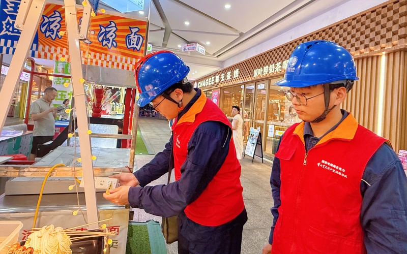 國網湖北電力員工對夜市攤位臨時線路、插排設備進行細致排查。江鈺瀟攝