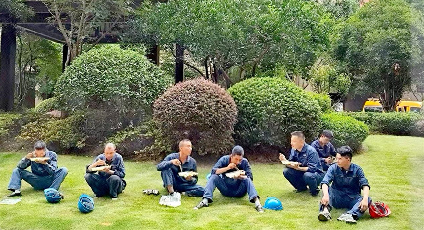 施工人員在草坪上匆忙午餐。