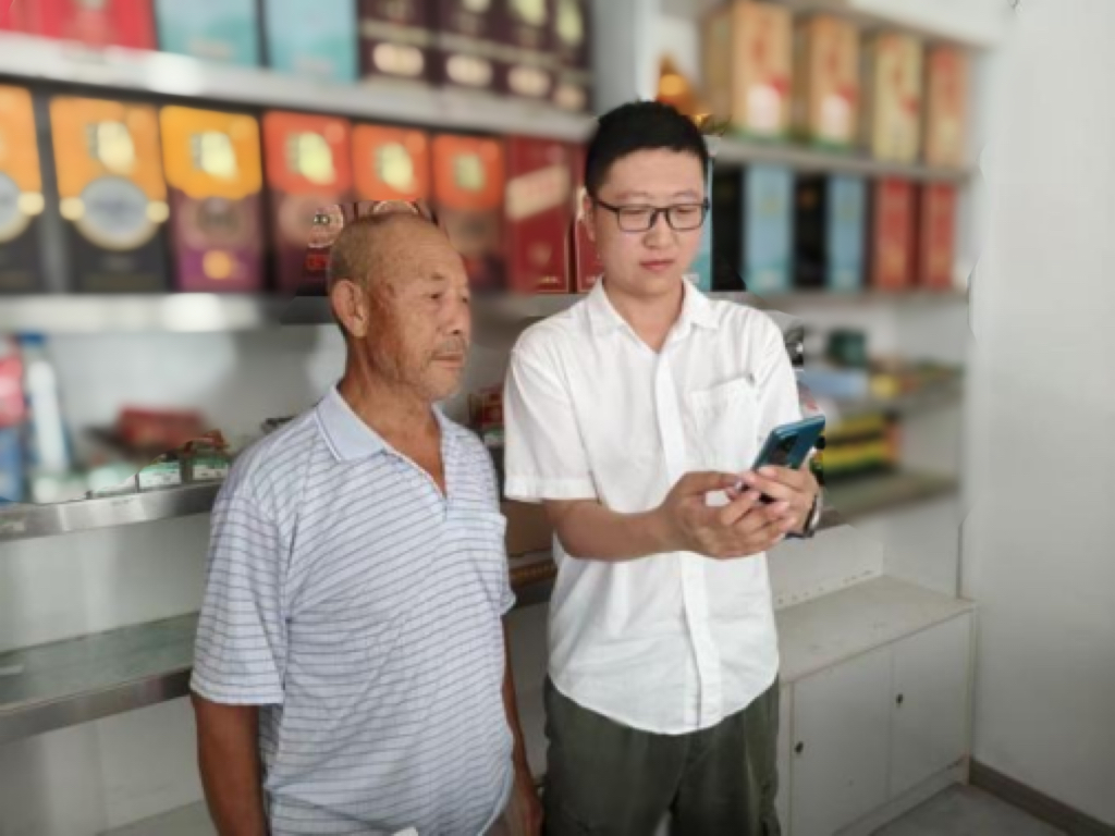 客户经理金文健指导店主在手机上操作系统