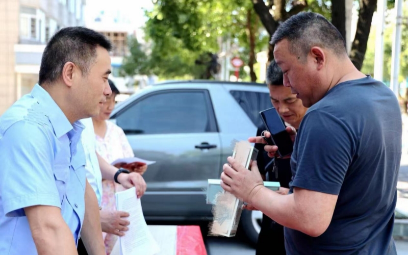 洪湖市局工作人员向群众讲解真假烟鉴别技巧。