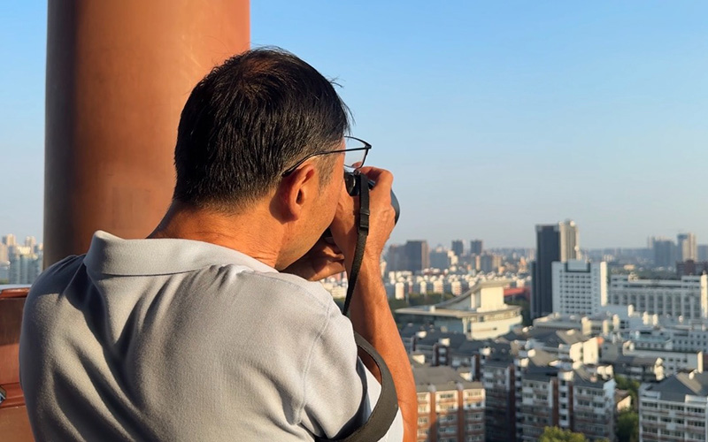 中外媒體湖北行嘉賓在黃鶴樓觀景台上拍攝武漢市景