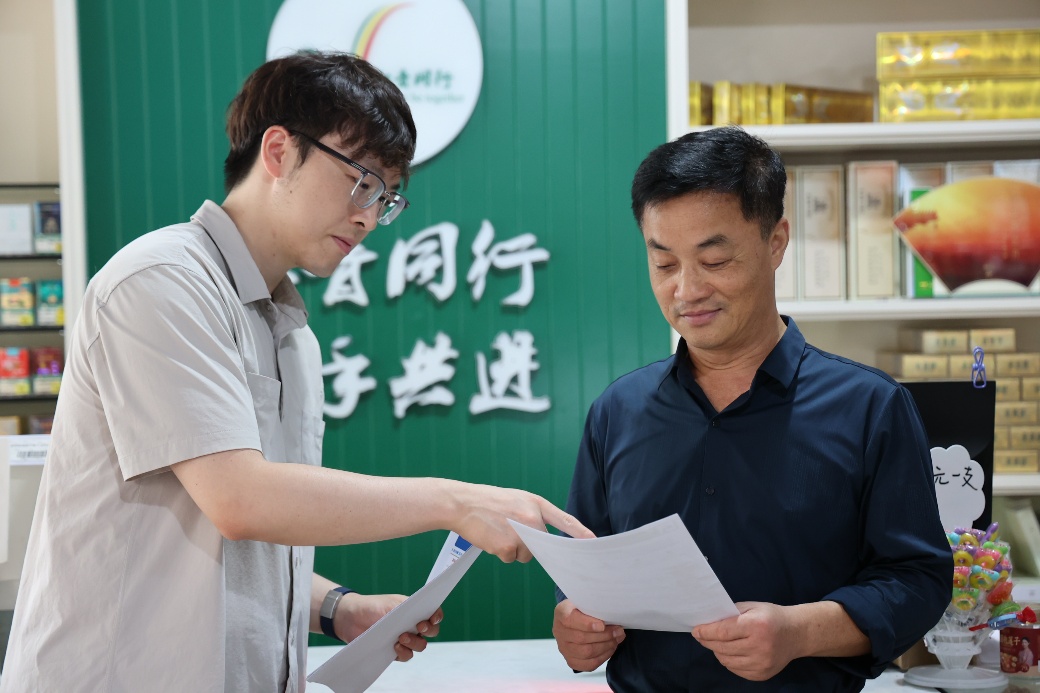 青年员工向零售户开展网络安全宣传。