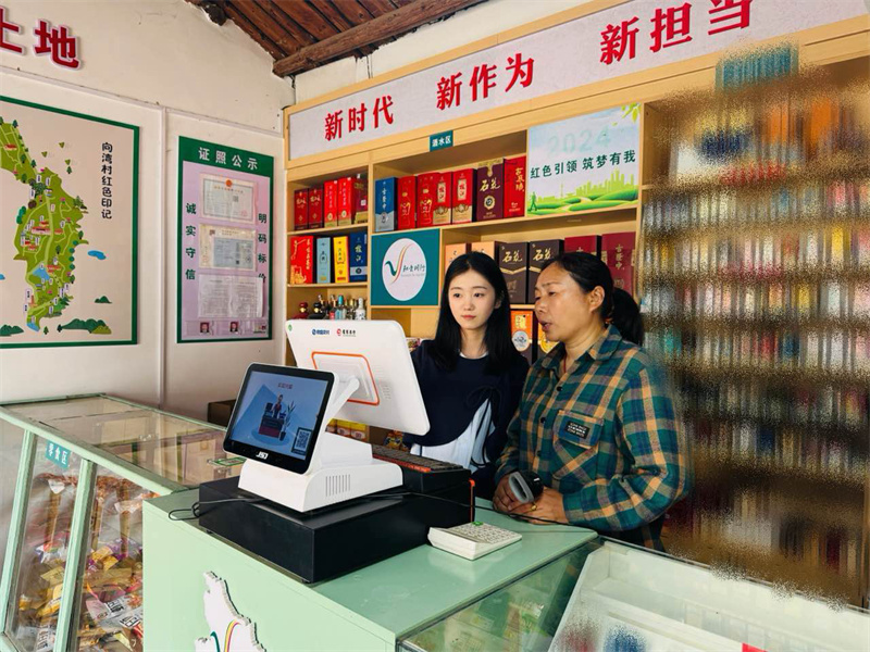 煙草客戶經理（左）在老供銷便利店內指導經營。