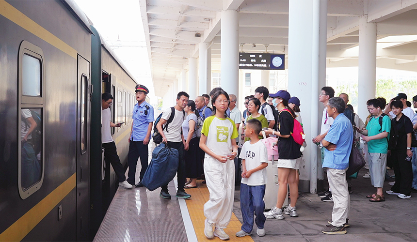 乘客在花園火車站新站台有序上車。縣融媒體中心供圖