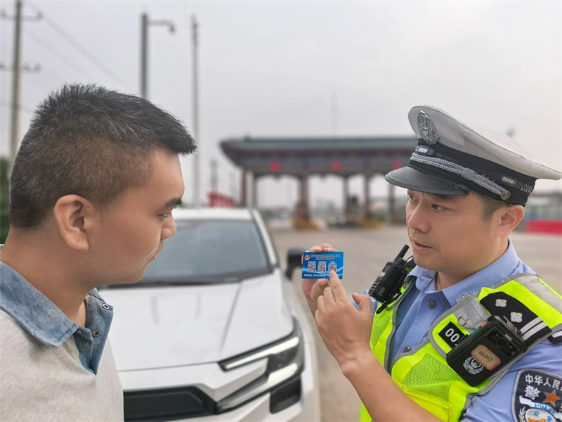 譚志剛向群眾發放便民卡片。