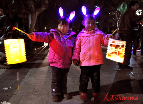 2月17日,小朋友手提灯笼行走在湖北省建始街头